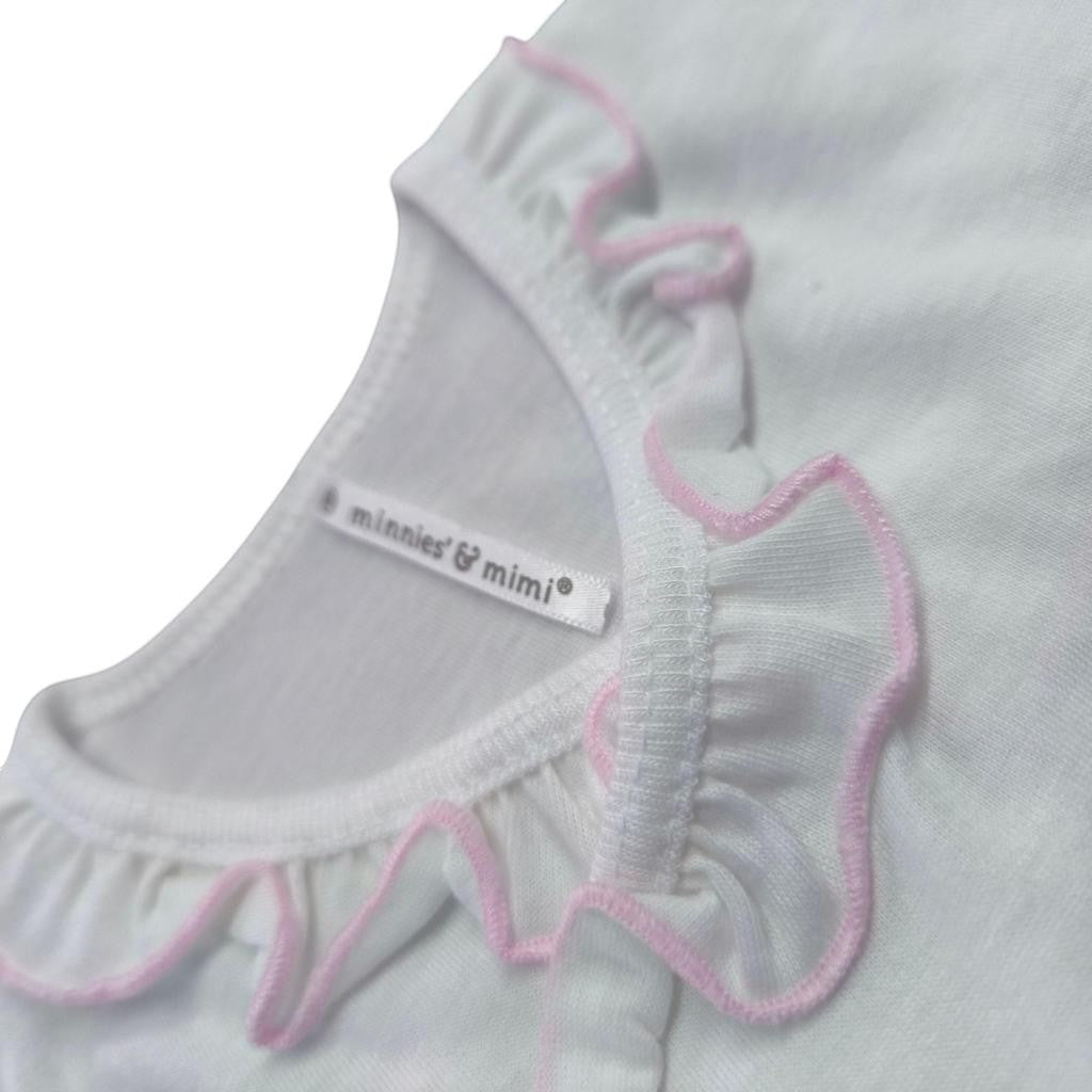 Close-up of a baby outfit with pink trim and 'minnies & mimi' label on a white background